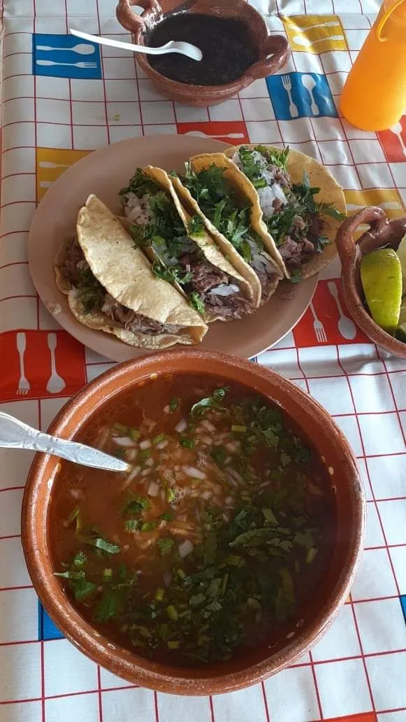 Tacos y consomé servidos en mesa